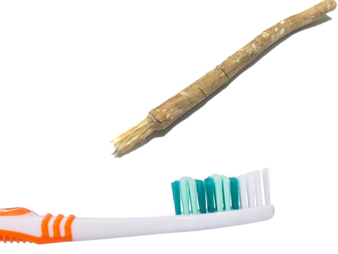 En tandbørste og en miswak, som er en træpind eller gren.